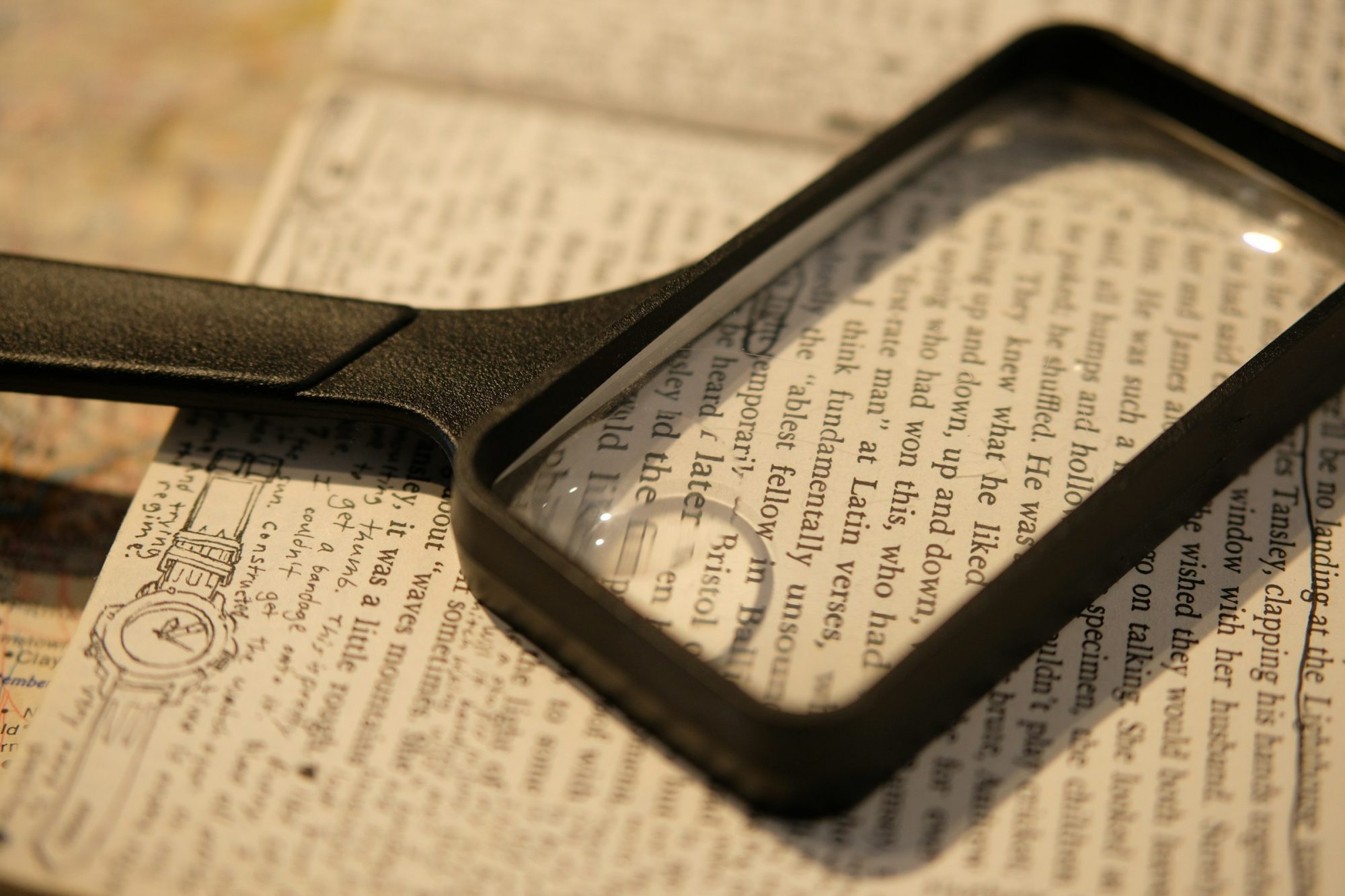 Una lente d'ingrandimento appoggiata su una pagina di testo stampato.