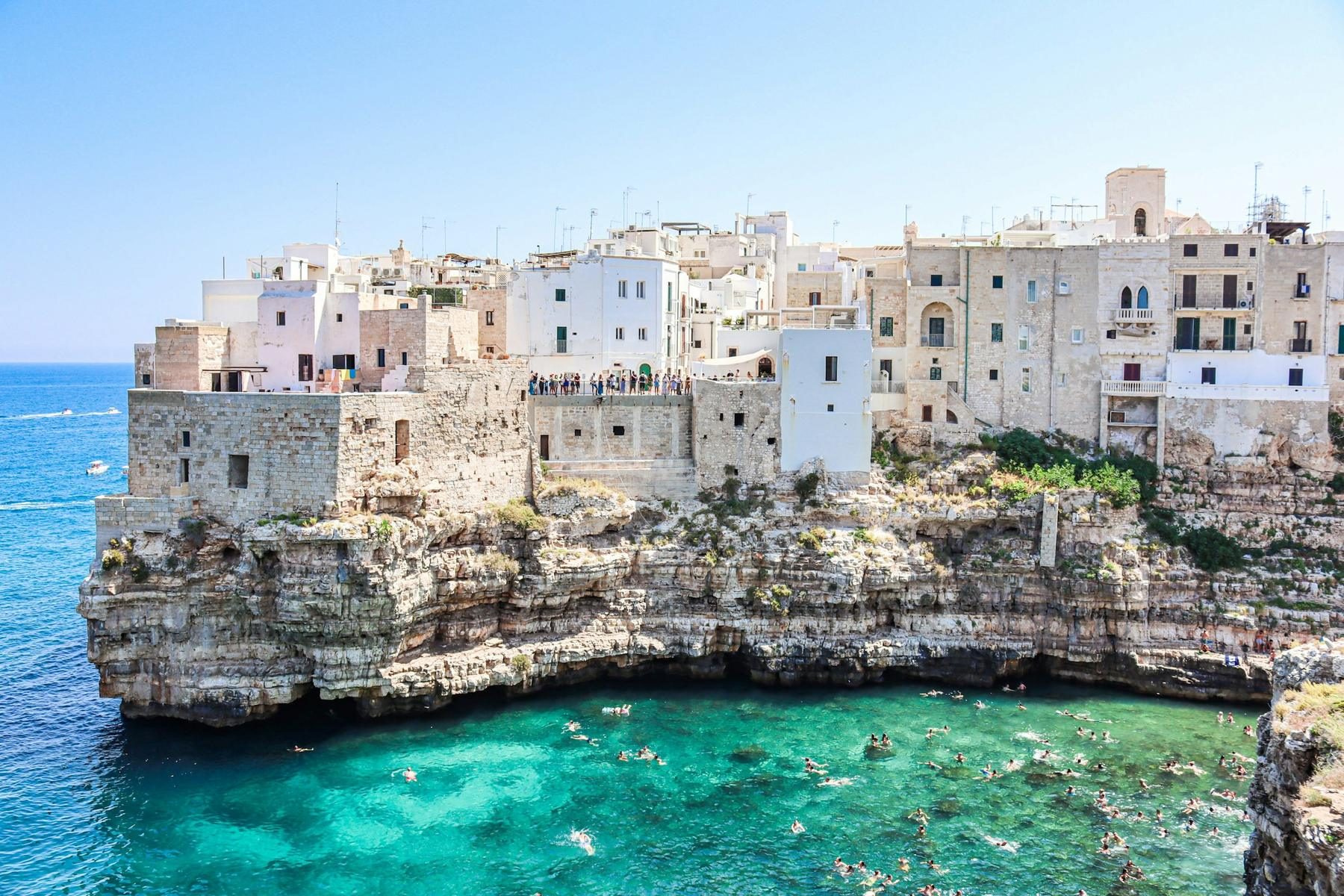 Case bianche sulla scogliera di Polignano a Mare affacciate sul mare turchese