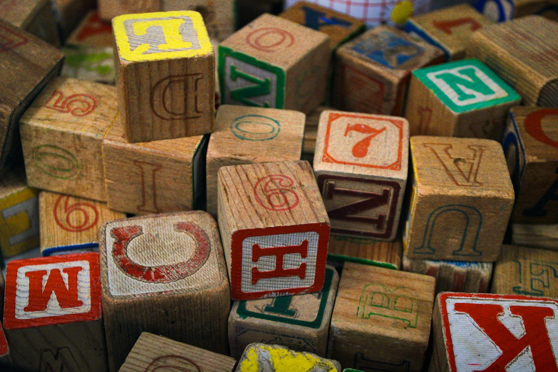 Un mucchio di vecchi cubi di legno con lettere e numeri colorati